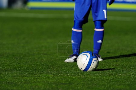 Téléchargez les photos : Jambes du joueur de football en vêtements de sport jouer avec le ballon sur l'herbe - en image libre de droit