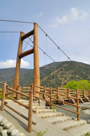 Photo for A wooden bridge over a river with a mountain in the background - Royalty Free Image