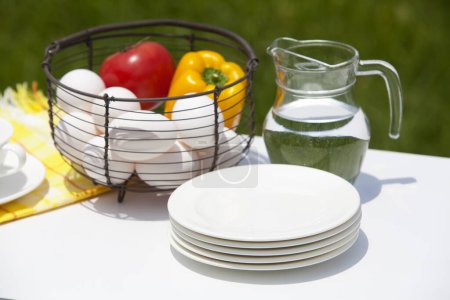 Téléchargez les photos : Légumes frais et oeufs dans un panier en osier sur la table à l'extérieur - en image libre de droit