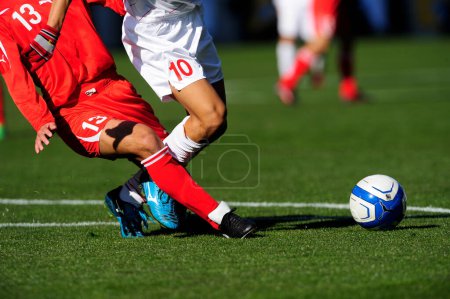 Foto de Piernas de futbolistas en ropa deportiva jugando con pelota sobre hierba - Imagen libre de derechos