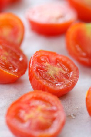 Foto de Vista de cerca de los tomates maduros cortados en mitades sobre la mesa. - Imagen libre de derechos
