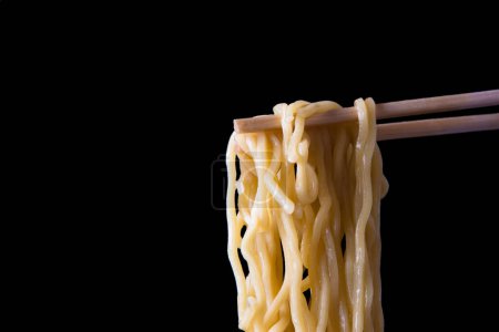 Photo for Asian noodles on chopsticks on black background - Royalty Free Image
