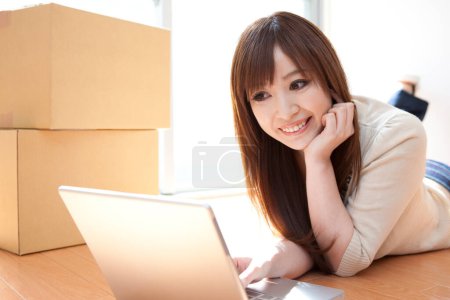 Photo for Asian woman using laptop computer at home - Royalty Free Image