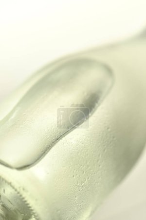 Téléchargez les photos : Gros plan de bouteille d'eau en verre sur la surface blanche - en image libre de droit
