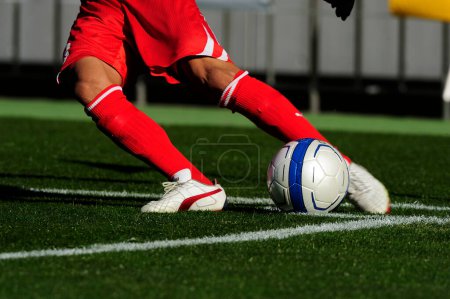 Photo for Legs of sports people in sportswear playing soccer on grass - Royalty Free Image