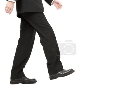 Téléchargez les photos : Section basse de l'homme d'affaires mâle marchant isolé sur fond blanc - en image libre de droit
