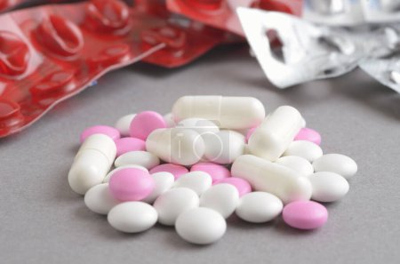 Foto de Vista de primer plano de tabletas, pastillas y cápsulas sobre fondo gris - Imagen libre de derechos