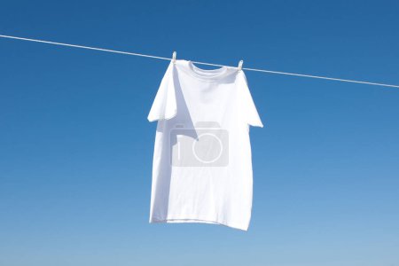 Foto de Camiseta en pinzas de tela contra el cielo azul - Imagen libre de derechos