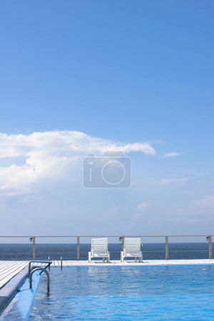 Photo for Empty swimming pool with white sunbeds - Royalty Free Image