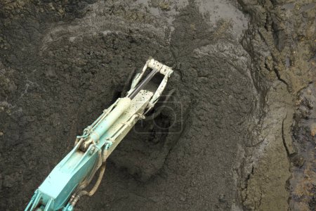 Téléchargez les photos : Excavatrice creuser la terre sur fond de nature - en image libre de droit