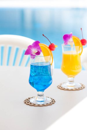Photo for Close-up view of glasses with cocktails near swimming pool - Royalty Free Image
