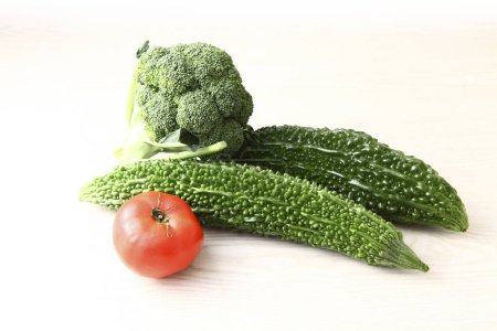 Téléchargez les photos : Légumes frais isolés sur fond blanc. Melons amers, tomates et brocoli - en image libre de droit
