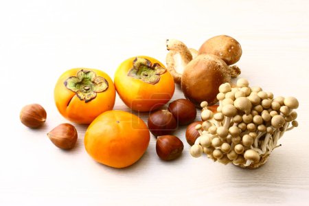 Foto de Surtido de caquis maduros, frutos secos y setas aislados sobre fondo blanco - Imagen libre de derechos