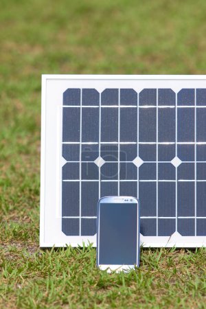 Foto de Smartphone y panel solar sobre hierba verde - Imagen libre de derechos