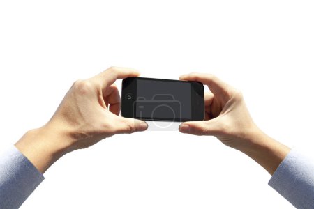 Foto de Recortado de la persona que sostiene el teléfono inteligente con pantalla en blanco sobre fondo de luz - Imagen libre de derechos