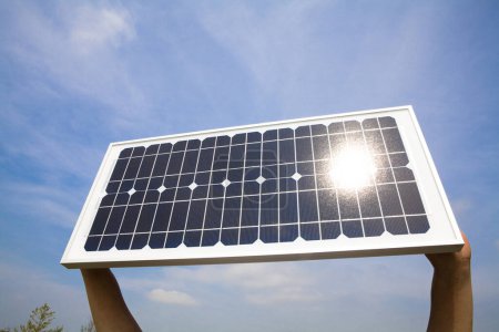 Foto de Manos sosteniendo el panel de energía solar sobre el cielo azul - Imagen libre de derechos