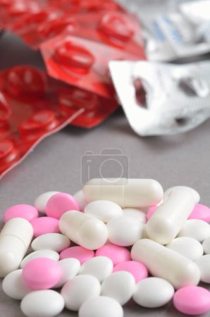 Téléchargez les photos : Vue rapprochée des comprimés, pilules et gélules sur fond gris - en image libre de droit