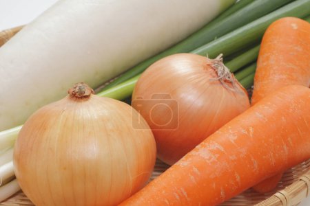 Foto de Cesta de verduras incluyendo zanahorias, cebollas y nabo chino - Imagen libre de derechos