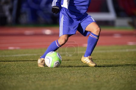 Foto de Un jugador de fútbol pateando una pelota de fútbol en un campo - Imagen libre de derechos
