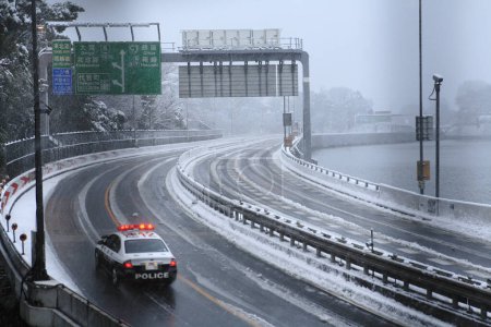 Téléchargez les photos : Voiture de police sur la route de la ville d'hiver - en image libre de droit