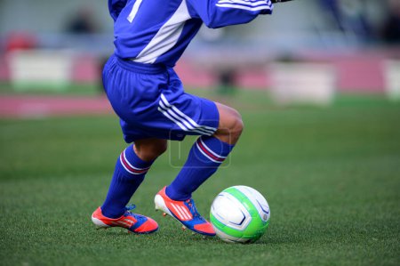 Foto de Un jugador de fútbol pateando una pelota de fútbol en un campo - Imagen libre de derechos