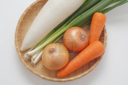 Foto de Cesta de verduras incluyendo zanahorias, cebollas y nabo chino - Imagen libre de derechos