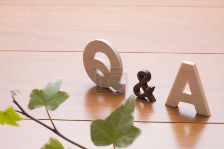 Téléchargez les photos : Q et un symbole sur une table en bois. concept des réponses aux questions. Lierre vert plante - en image libre de droit
