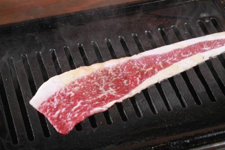 Foto de Se está cocinando un trozo de carne en una parrilla - Imagen libre de derechos