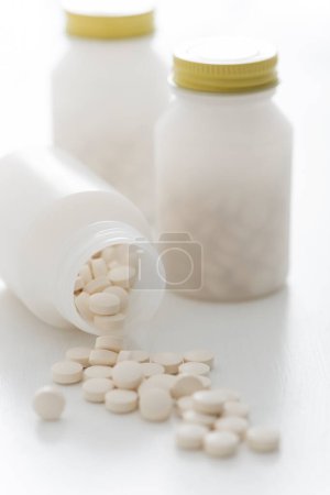 Photo for Close-up view of pills in bottles on white background - Royalty Free Image