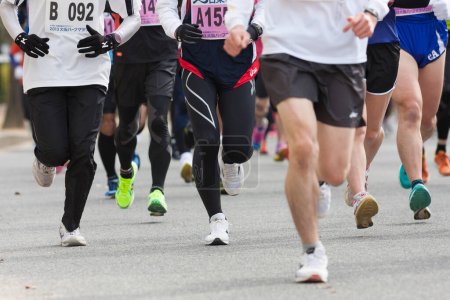 Foto de Concepto deportivo, piernas de la gente corriendo maratón vista de fondo - Imagen libre de derechos