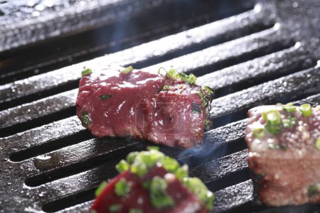 Photo for Beef steaks on grill with herbs and spices. - Royalty Free Image