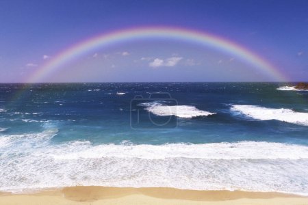 Téléchargez les photos : Magnifique arc-en-ciel et vagues marines bleues - en image libre de droit