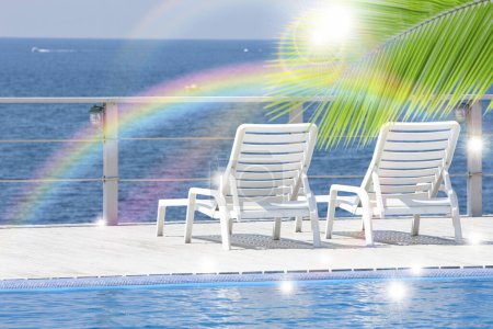 Téléchargez les photos : Chaises longues à la piscine avec vue sur l'arc-en-ciel - en image libre de droit