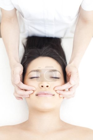 Téléchargez les photos : Belle asiatique femme obtention visage massage à spa salon - en image libre de droit