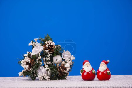 Foto de Figuras de Santas sentadas junto a decoraciones navideñas - Imagen libre de derechos