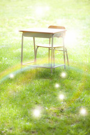Photo for Empty school desk on green field - Royalty Free Image