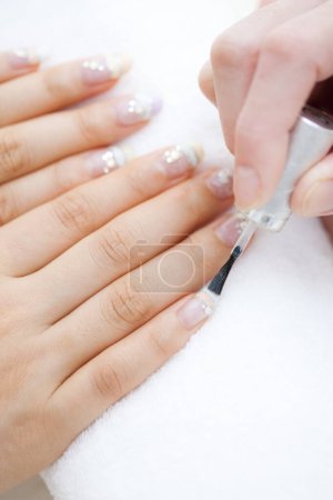 Photo for Laying nail polish on a woman's nails, close up - Royalty Free Image