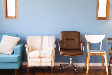 Téléchargez les photos : Plan intérieur de belle maison moderne avec différentes chaises sur fond de mur bleu - en image libre de droit