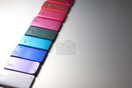 Téléchargez les photos : Vue rapprochée de différents téléphones mobiles modernes colorés sur fond gris - en image libre de droit