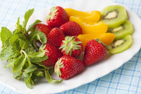 Photo for Fruit plate with strawberries, pickled peaches and kiwi - Royalty Free Image