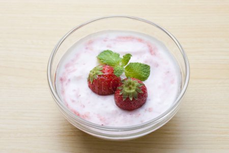 Photo for Delicious dessert in glass bowl with yogurt and fresh strawberries - Royalty Free Image