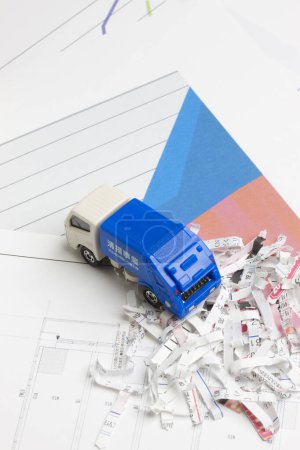 Foto de Modelo en miniatura de coche de basura azul y papel rallado - Imagen libre de derechos