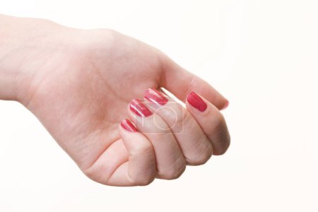 Téléchargez les photos : Main féminine avec manucure rouge sur fond blanc - en image libre de droit