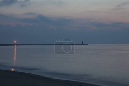 Téléchargez les photos : Phare sur la plage au coucher du soleil - en image libre de droit
