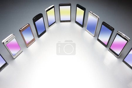 Photo for Close-up view of mobile smart phones on grey background. - Royalty Free Image