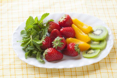 assiette de fruits aux fraises, pêches marinées et kiwi