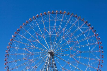 Téléchargez les photos : Grande roue dans le parc d'attractions contre le ciel bleu - en image libre de droit