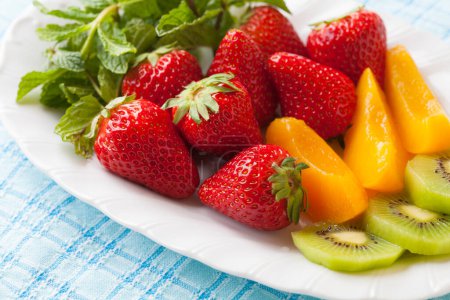 assiette de fruits aux fraises, pêches marinées et kiwi