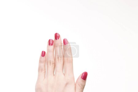 Foto de Mano femenina con manicura roja sobre fondo blanco - Imagen libre de derechos