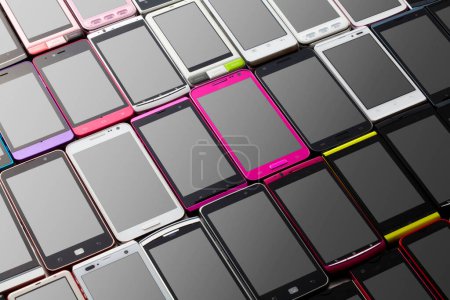 Téléchargez les photos : Téléphones mobiles modernes avec différentes couleurs sur fond sombre - en image libre de droit